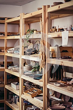 Many different pottery standing on the shelves in a potery workshop photo
