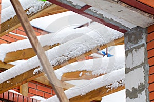 Wooden rafters for the roof covered with snow