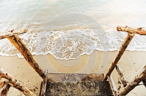 Wooden railing with sand beach in morning light