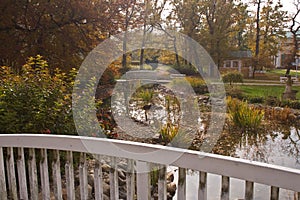 Wooden railing by small water stream.