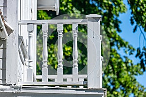 Wooden railing of a white balcony of a house..