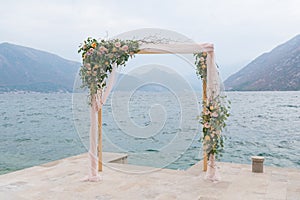 Wooden rectangular wedding arch decorated with flowers