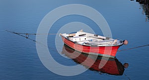 Wooden red boat on the water of a small port