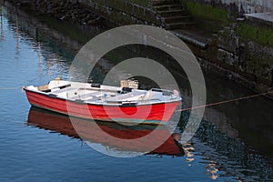 Wooden red boat on the water of a small port