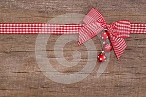 Wooden red christmas background with a white checked ribbon photo
