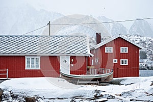 Wooden red house of fishing village in snowy covered on winter at Lofoten islands