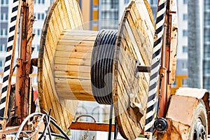 Wooden reel with high voltage cable mounted on a trailer for easy transport and stowage. Laying a high-voltage power cable in the