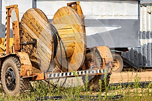Wooden reel with high voltage cable mounted on a trailer for easy transport and stowage. Laying a high-voltage power cable in the