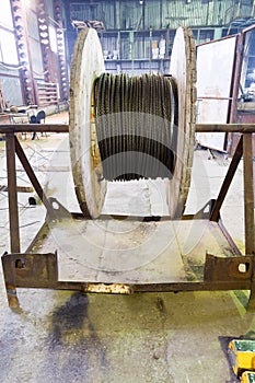 Wooden reel with steel rope in warehouse