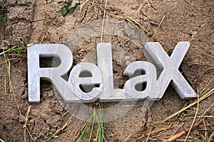 Wooden Relax Sign on Sandy Beach by the sea