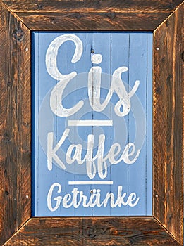 Wooden restaurant sign with offers. Letter with Kaffee Eis GetrÃÂ¤nke means Coffee Ice Drinks