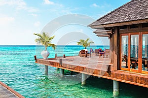 A wooden restaurant on the water against the backdrop of the azure waters of the Indian Ocean, Maldives