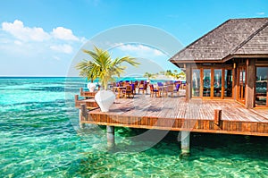 A wooden restaurant on the water against the backdrop of the azure waters of the Indian Ocean, Maldives