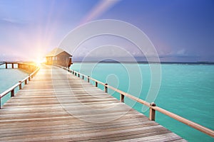 The wooden road over the sea to traditional lodges on piles