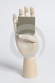 Wooden robot hand holding central processing unit CPU microchip