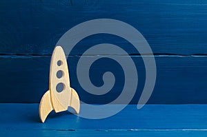 A wooden rocket on a blue background. The style is retro. The concept of space flights and achievements in high technologies. Busi