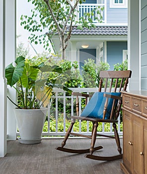 Wooden rocking chair on front porch with pillow