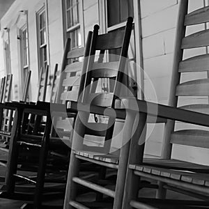 Wooden rocking chairs lined up on a porch