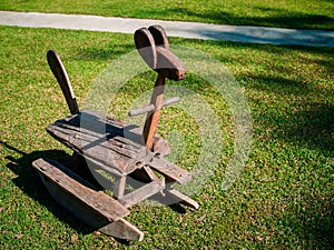 Wooden rocking horse. Lonely old vintage swinging horse on the green backyard.