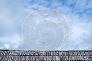 Wooden roof with cloudy sky in background