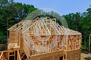 Wooden roof framework on stick built home under construction of attic beam framing against