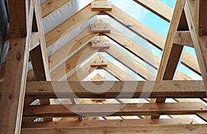 Wooden roof framing with a close-up of rafters, roof beams and purlins framing during roofing construction