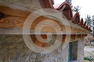Wooden roof of house with tiles and stone