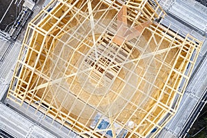 Wooden roof truss beams during construction building of a house aerial view