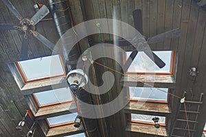 Wooden roof with windows overlooking the sky and ceiling fans