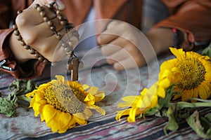 Wooden Rosary in hand. Young junior lady holding rosary tightly. Female hands holding a rosary with Jesus Christ Cross Crucifix.