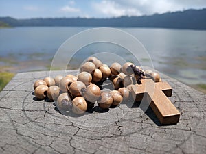 Wooden rosary on wood  with Jesus Christ Cross Crucifix. Christian Catholic religious symbol of faith concept. Copy space for your