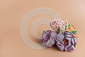 On wooden round background lie natural marshmallows in the form of purple peony flowers