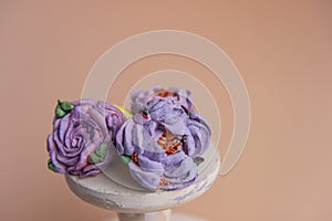 On wooden round background lie natural marshmallows in the form of purple peony flowers