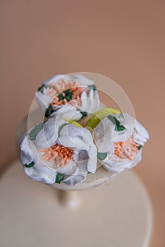 On wooden round background lie natural marshmallows in the form of white chamomile flowers