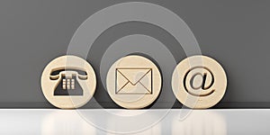 Wooden round telephone, envelope letter and e-mail symbols leaning against dark grey wall background, contact us symbols or banner