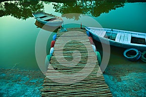 Wooden row boat . green shade. boat dock and wooden boat