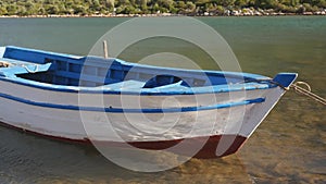 A wooden row boat tied up to a pier