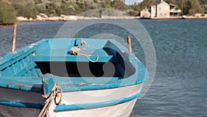 A wooden row boat tied up to a pier