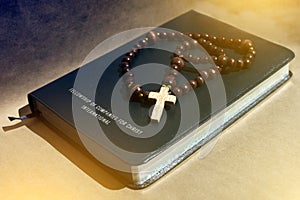 A wooden rowan on a black leather bible that shifts the light