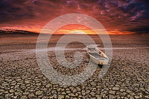 Wooden Rowboat on cracked soil in climate drought
