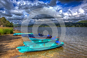 Wooden rowing boats by lake with mountains and blue sky the Lake District Cumbria England UK in HDR like painting