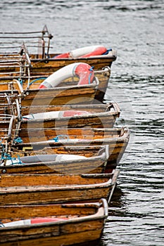 Wooden rowing boats moored up against a jetty in the Cotswolds