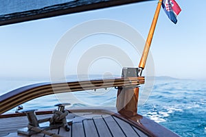Wooden rudder on small wooden boat and blue sea