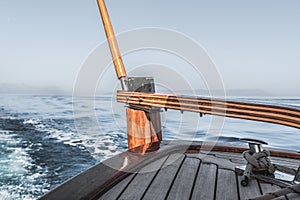 Wooden rudder on small wooden boat and blue sea