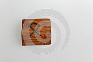 Wooden rune which means - heritage, estate, possession, lie on a table on a white background photo