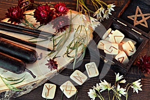 Wooden runes and black candles on witch table