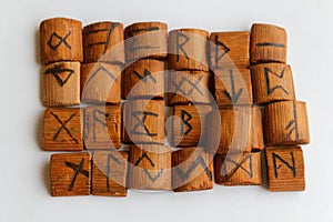 Wooden runes lie on a table on a white background