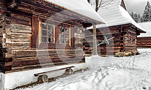 Wooden rural cottage in snowy village in winter