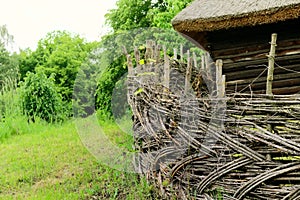 Wooden rural fence in village near the house near the forest. Authentic traditional culture in architecture and life. Sunlight,