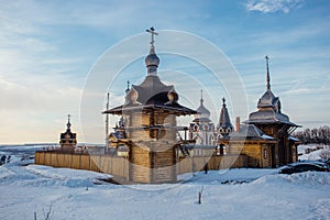 Wooden Russian church courtyard in sunny winter day